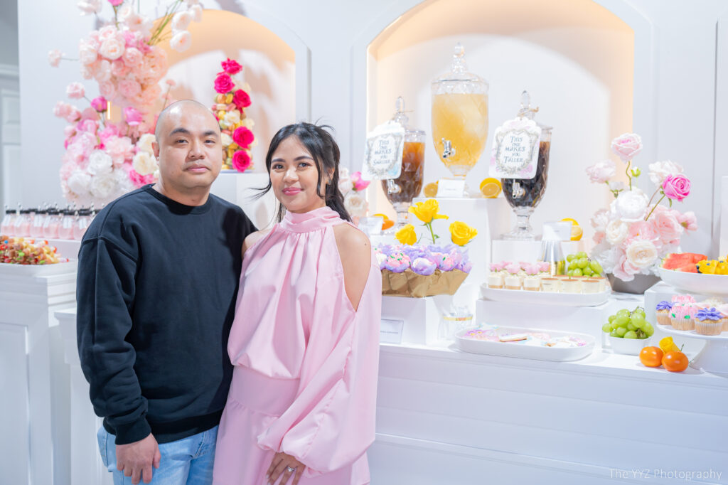 Couple posing at a dessert table.