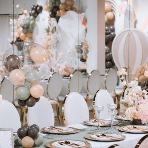 Elegant event setup with balloons and flowers.